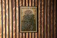 A vintage-style poster of a jade plant flower is displayed on a wooden wall.