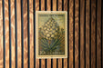A 10c U.S. postage stamp featuring a Joshua tree flower is displayed on a wooden wall.