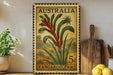 A vintage Australian postage stamp featuring a kangaroo paw plant is displayed on a shelf next to a wooden cutting board and some potted plants.
