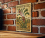 A vintage Australian postage stamp featuring a kangaroo paw plant is displayed on a brick wall.