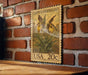 A wooden table with a brick wall in the background, featuring a vintage-style postage stamp depicting a yellow flower.