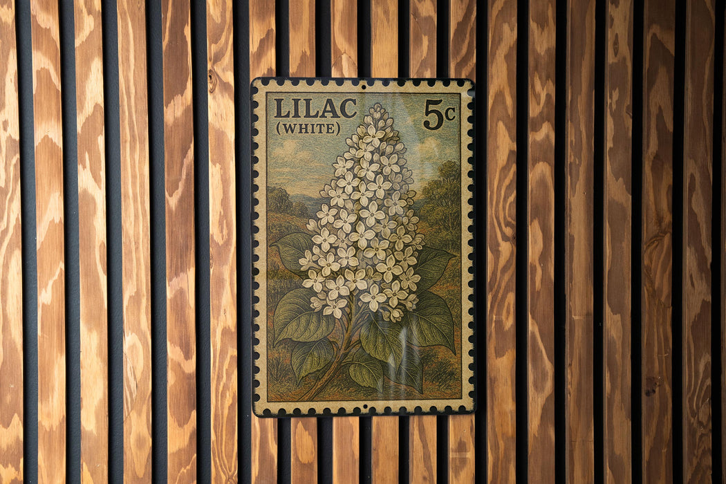 A vintage postage stamp featuring a detailed illustration of a white lilac flower, mounted on a wooden wall.