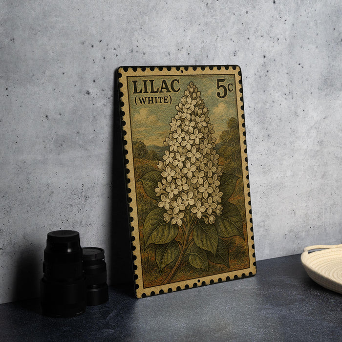 A vintage postage stamp featuring a detailed illustration of a white lilac flower, with the text "LILAC (WHITE)" and the value "5c" printed on it.