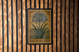 A framed illustration of a lily of the Nile flower is displayed on a wooden wall.