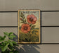 A vintage-style metal sign with a floral illustration of two red flowers and green leaves, mounted on a wall.