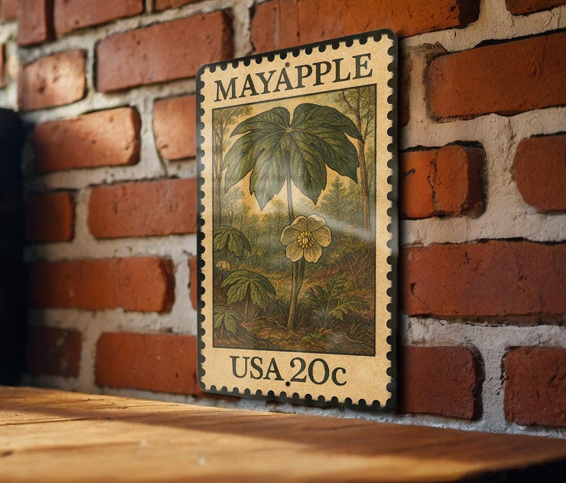 A vintage-style metal stamp with a floral illustration and text, mounted on a brick wall.