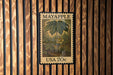 A framed image of a leafy plant, possibly a Mayapple, is displayed on a wooden wall.