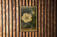A U.S. postage stamp featuring a yellow flower is displayed on a wooden wall.