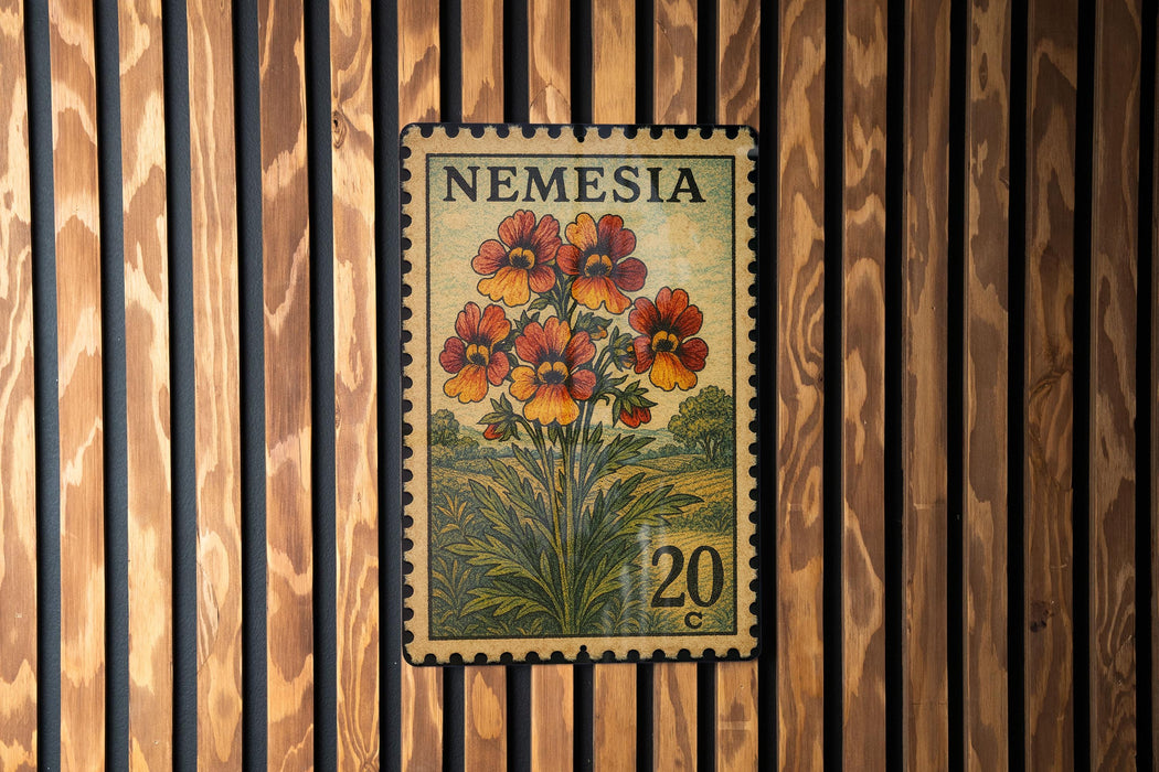 A vintage-style postage stamp from Nemeria, featuring a floral design with red and orange flowers, is displayed on a wooden wall.