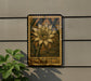 a decorative sign with a large yellow flower on it, mounted on a wall next to a plant.