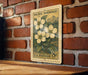 A vintage U.S. postage stamp featuring a floral design is displayed on a brick wall.