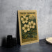 A vintage U.S. postage stamp featuring a floral design, placed on a gray surface next to some black camera lenses.