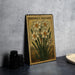 A framed illustration of a daffodil plant with the text "PAPERWHITE NARCISSUS" on it, placed on a gray countertop next to some black camera lenses.