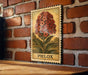 A wooden table with a brick wall in the background, and a framed illustration of a flower on the wall.