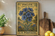 A vintage-style postage stamp featuring a blue wild blue flower, placed on a wooden surface next to a wooden cutting board and some lemons.