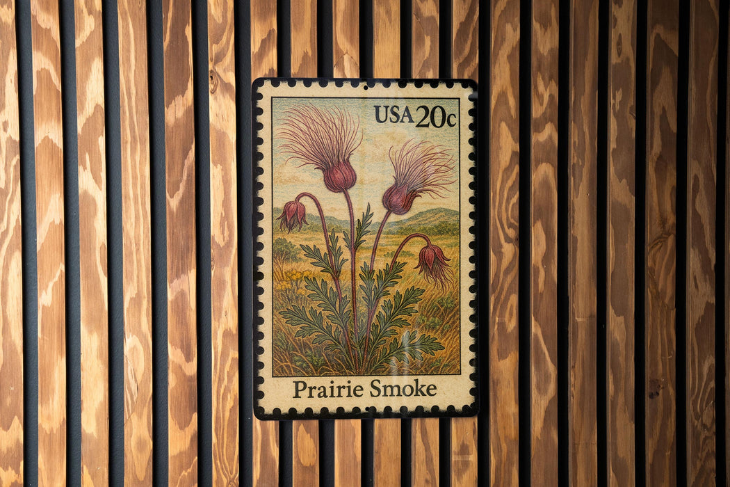 A postage stamp featuring a depiction of a prairie smoke flower, which is a type of wildflower commonly found in the prairies of North America.