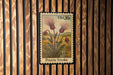 A postage stamp featuring a depiction of a prairie smoke flower, which is a type of wildflower commonly found in the prairies of North America.