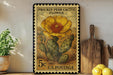 A framed postage stamp depicting a Prickly Pear Cactus flower, with a 5 cent value, is displayed on a shelf next to a wooden cutting board and a potted plant.