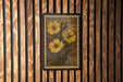A vintage-style postage stamp featuring a yellow flower on a wooden background.