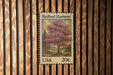 A United States postage stamp featuring a redbud tree, which is a type of flowering tree native to eastern North America.