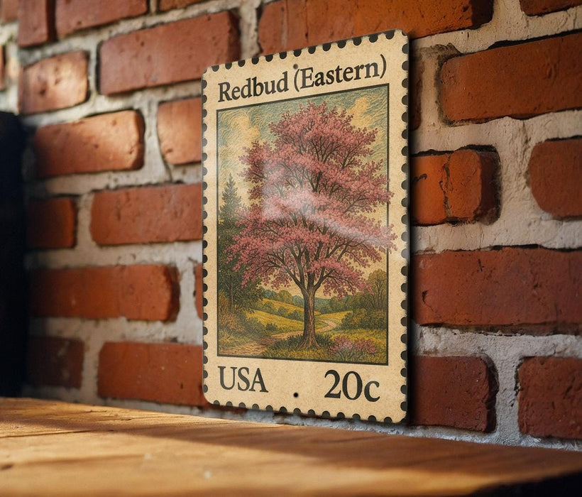 A wooden table with a framed stamp depicting a tree with pink flowers, mounted on a brick wall.