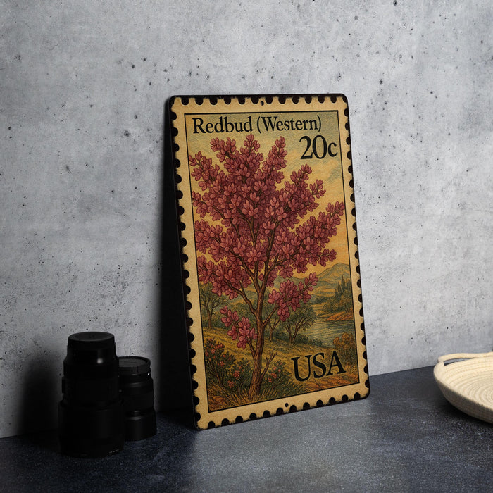 A 20c postage stamp from the United States, featuring an illustration of a redbud tree, is displayed on a table.