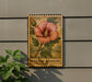 A wooden sign with a floral illustration and the text "ROSE of SHARON" is displayed on a wall, accompanied by a small green plant.