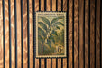A vintage-style postage stamp from Solomon's Seal, featuring a lily of the valley plant, is displayed on a wooden wall.