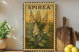 a framed illustration of a spirea plant with yellow flowers, placed on a shelf next to a wooden cutting board and a potted plant.