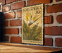 A vintage postage stamp featuring a tropical flower and leaves, mounted on a brick wall.
