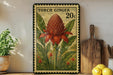 A vintage-style metal sign with a large illustration of a red flower surrounded by green leaves, placed on a wooden shelf next to a wooden cutting board and a potted plant.