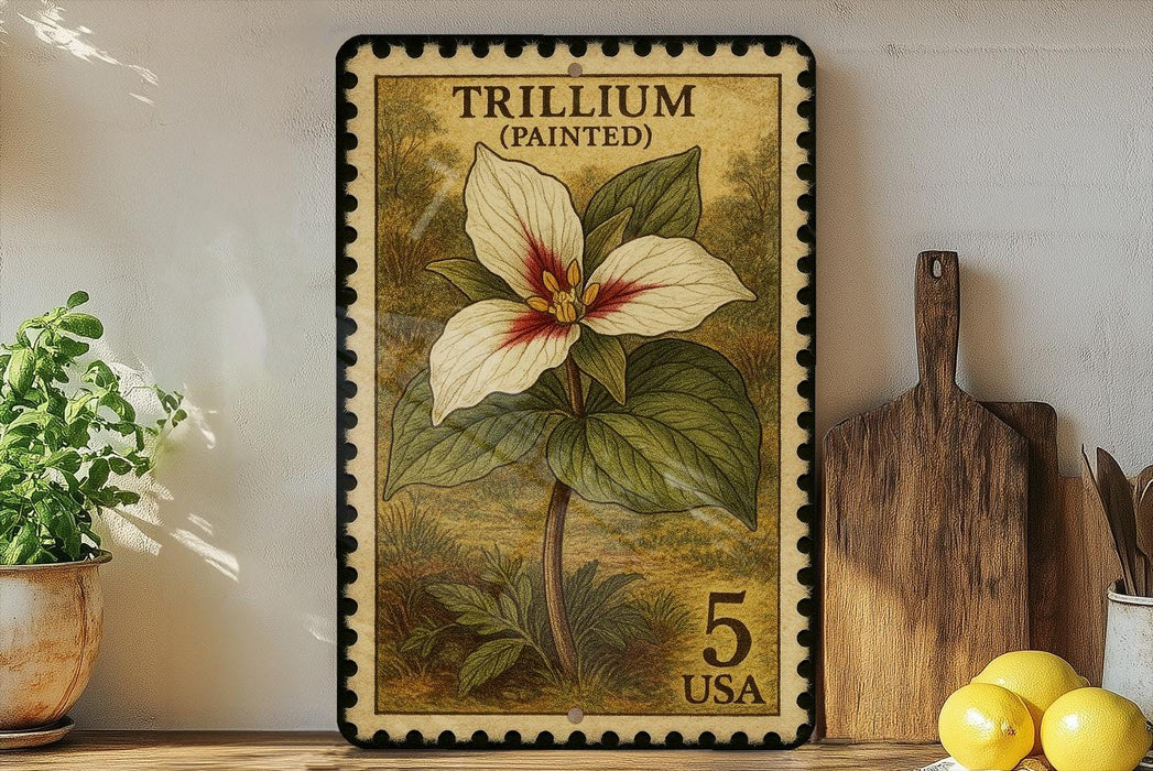 A framed stamp depicting a Trillium flower, which is a type of wildflower, is displayed on a shelf next to a wooden cutting board and some lemons.