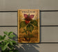 A wooden sign with a trillium flower and leaves, mounted on a wall, with a plant to the left.