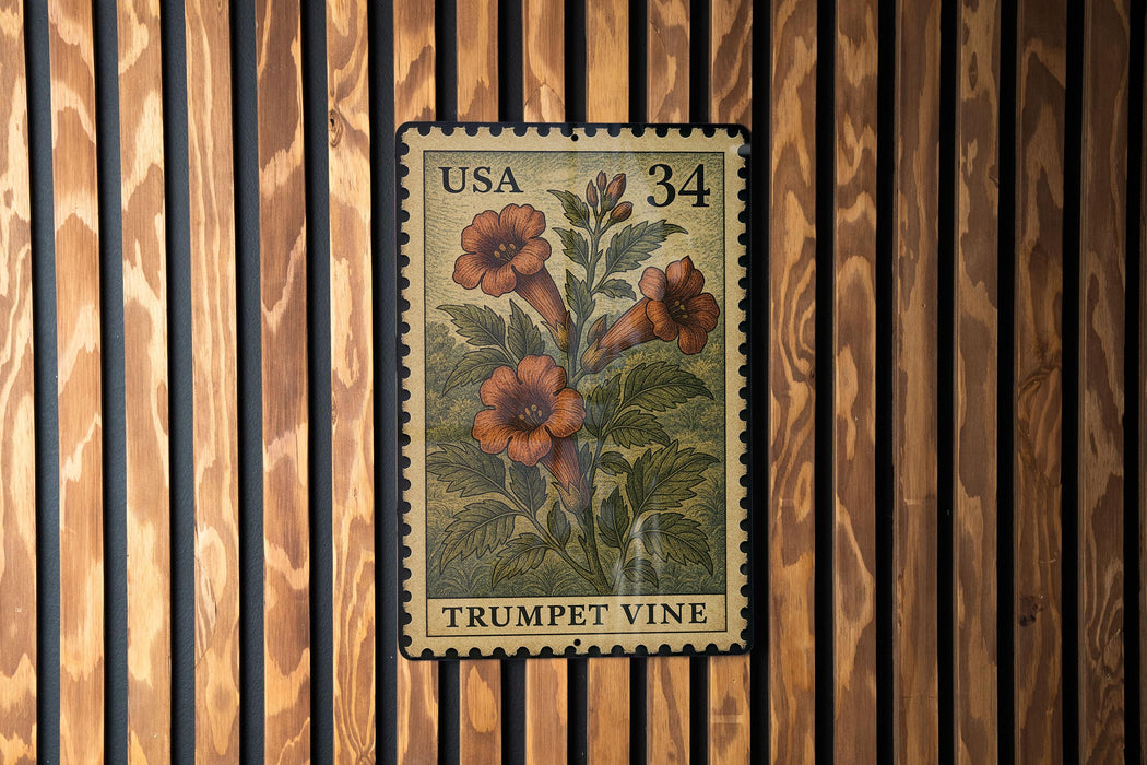 A U.S. postage stamp featuring a trumpet vine plant is displayed on a wooden wall.