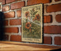 A vintage-style stamp depicting a trumpet vine, with the text "USA 34" and "TRUMPET VINE" printed on it, is displayed on a brick wall.