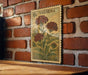 a vintage-style postage stamp with a floral design, mounted on a brick wall.
