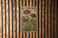 A vintage-style postage stamp featuring a floral illustration is displayed on a wooden wall.