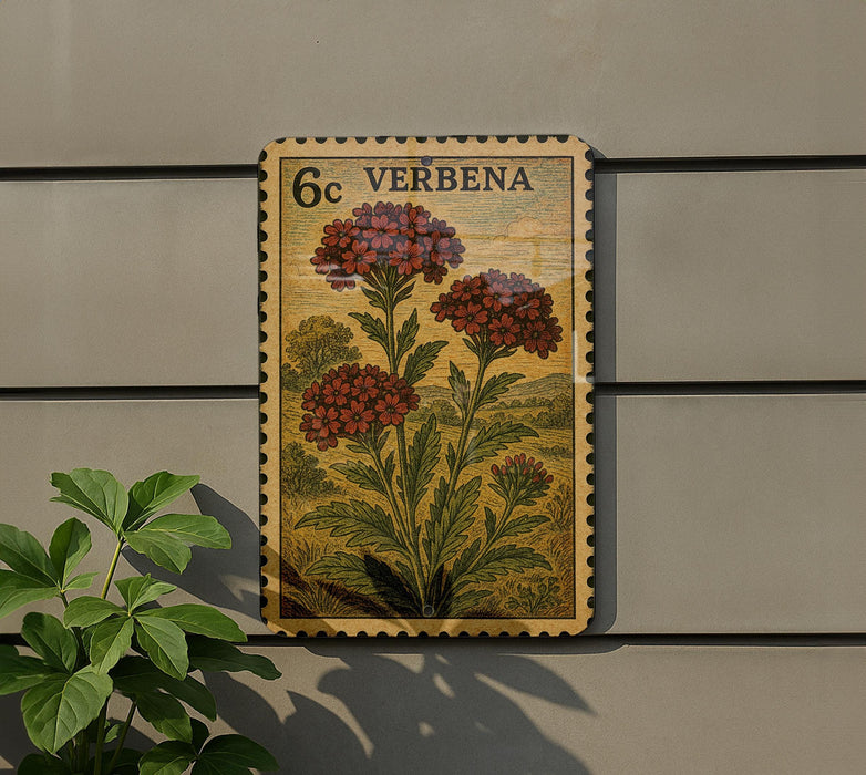a vintage-style postage stamp with a floral design, mounted on a wall next to a plant.