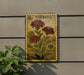 a vintage-style postage stamp with a floral design, mounted on a wall next to a plant.