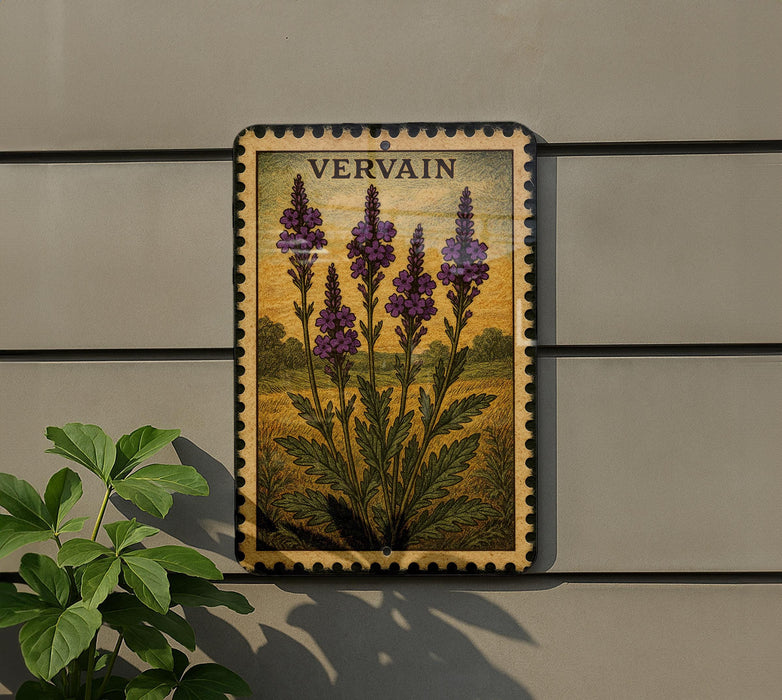 a framed illustration of purple flowers on a wall, with a plant to the left of the frame.