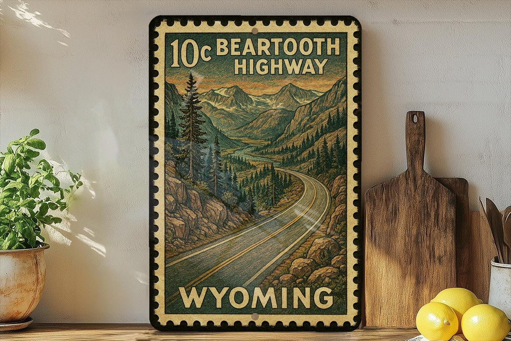 A vintage-style poster of the 10c Bear Tooth Highway in Wyoming, featuring a winding road surrounded by mountains and pine trees.