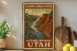 A framed vintage-style poster of Flaming Gorge-Uintas, a scenic byway in Utah, is displayed on a shelf next to a wooden cutting board and some lemons.