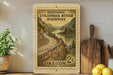 a wooden frame with a postage stamp design depicting a scenic highway in Oregon, surrounded by mountains and a river.