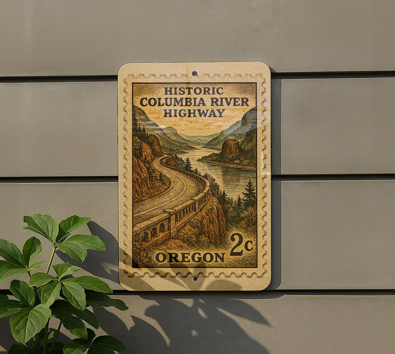 A postage stamp depicting a scenic highway in Oregon, with a winding road and mountains in the background.