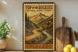 A vintage-style metal sign with a mountain landscape and a winding road, advertising "Top of the Rockies National Scenic Byway" in Colorado.