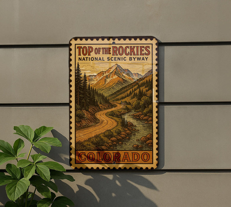 A vintage-style sign for the Top of the Rockies National Scenic Byway in Colorado, featuring a scenic mountain landscape with a winding road.