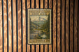 A vintage-style postage stamp from California, featuring a scenic mountain landscape with a winding road and pine trees.