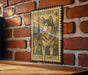 A vintage U.S. postage stamp featuring a husky dog is displayed on a brick wall.