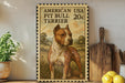 A framed illustration of an American Pit Bull Terrier dog, with a postage stamp design, is displayed on a shelf next to a wooden cutting board and some lemons.