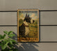 A U.S. postage stamp featuring a Great Dane dog, mounted on a wall next to a plant.